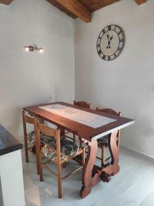 einen Esstisch mit Stühlen und eine Uhr an der Wand in der Unterkunft Assisi il Panorama in Petrignano
