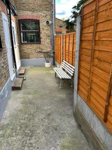 a bench sitting in a courtyard next to a building at Room in Trumpington London in London