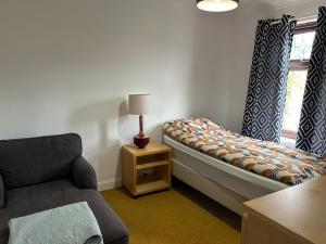 Habitación con cama, silla y ventana en Room in Trumpington London, en Londres