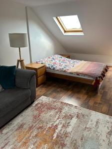 a living room with a bed and a couch at Room in Trumpington London in London