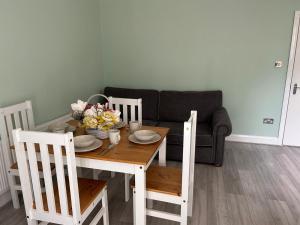 a dining room table and chairs with a couch at Room in Trumpington London in London