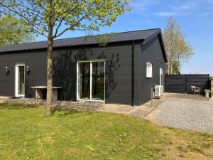 een zwart huis met een zwart dak bij Country Home in Hejnsvig
