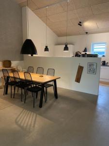 a dining room with a wooden table and chairs at Country Home in Hejnsvig