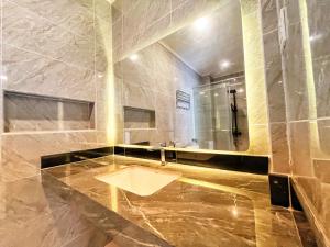 ein Bad mit einem Waschbecken und einem Spiegel in der Unterkunft Billiards And Karaoke, Free Pickup in Sengkuang
