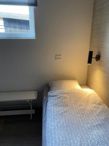 um pequeno quarto com uma cama e uma janela em Country Home em Hejnsvig
