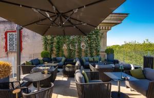 a patio with tables and chairs and an umbrella at The First Musica in Rome