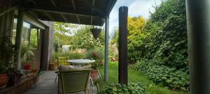 un patio con mesa y sillas en un jardín en Chambre avec terrasse Chez Anne, en Rennes