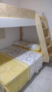 um quarto de boneca com um beliche com um cobertor amarelo em Lindo Apartamento en Sabaneta em Sabaneta