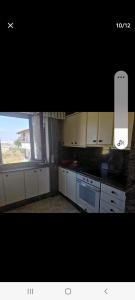 une cuisine avec des placards blancs et une grande fenêtre dans l'établissement Apartamento playa, à Laredo