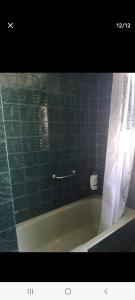 La salle de bains est pourvue d'une baignoire avec rideau de douche. dans l'établissement Apartamento playa, à Laredo
