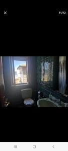 La salle de bains est pourvue de toilettes, d'un lavabo et d'un miroir. dans l'établissement Apartamento playa, à Laredo