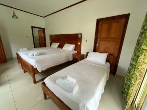 a hotel room with two beds and a mirror at Bethel's Villas in La Digue