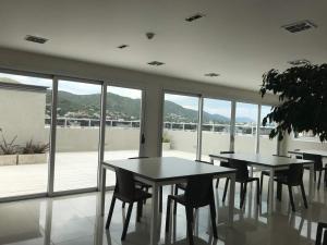 2 Tische und Stühle in einem Zimmer mit Fenstern in der Unterkunft Departamento Opera Torre 2 in Villa Carlos Paz