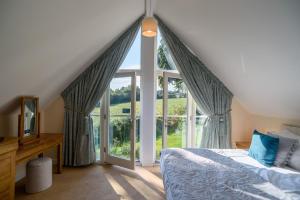 a bedroom with a bed and a large window at Luxurious 3 Bedroom New England Style Villa - Trewhiddle V7 in St Austell
