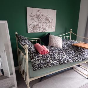 1 cama con almohadas y pared verde en Jolly Piece, en Castleford