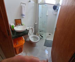 a bathroom with a toilet and a sink at Apartamento in Capitólio