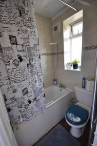 a bathroom with a bath tub and a toilet and a window at 5 SLEEPER CLOSE TO OLD STREET/ SHOREDITCH in London