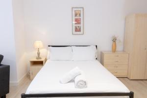 a bedroom with a large white bed with two towels on it at Cosy Studio Apt in Preston near City Centre in Preston