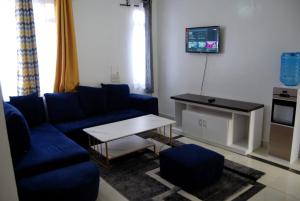 sala de estar con sofá azul y mesa en Annydo Superior Homes en Nairobi