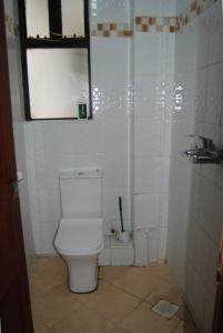 Baño blanco con aseo y lavamanos en Annydo Superior Homes en Nairobi