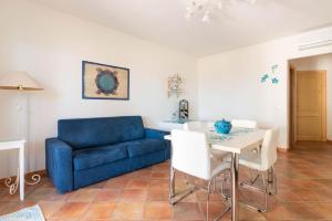 カステルサルドにあるLa Casa Bianca a due minuti a piedi dal mareの青いソファとテーブルのあるリビングルーム