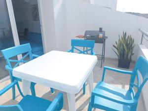 Biały stół i niebieskie krzesła na balkonie w obiekcie Panoramic 2 View to the ocean Manta w mieście Manta