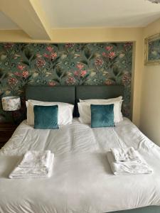 1 cama blanca grande con 2 toallas en The Lion Hotel, en Llansantffraid-ym-Mechain