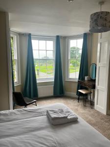1 dormitorio con 1 cama, escritorio y ventanas en The Lion Hotel, en Llansantffraid-ym-Mechain