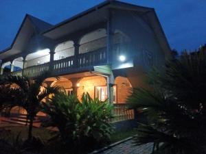 a large house with a balcony at night at Bethel's Villas in La Digue