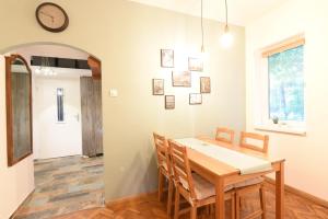 a dining room with a table and chairs and a clock on the wall at Nookbed in Budapest