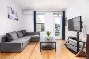 een woonkamer met een bank en een tv bij AAA Location - Bright and Cozy Apartment in Montreal