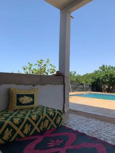 een bed op de veranda van een huis bij villa avec piscine à louer in Bir Jedíd Saint-Hubert