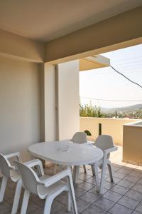 Villa Irini في Patsídhes: طاولة بيضاء وكراسي على الفناء