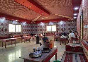 a restaurant with people sitting at tables in a room at Wadi Rum Calma camp in Aqaba