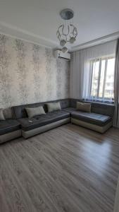 a living room with a couch in the middle of a room at Квартира в новом жилом комплексе Invest House in Tashkent