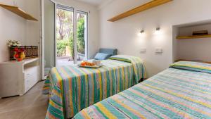 1 Schlafzimmer mit 2 Betten und einem Tisch mit einer Obstschale in der Unterkunft LA VILLA IN PINETA 10, Emma Villas in Castiglione della Pescaia
