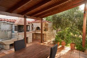 patio esterno con tavolo in legno e forno all'aperto di Villa Irini a Patsídhes