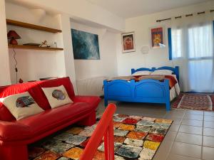 ein Schlafzimmer mit einem Bett und einem roten Sofa in der Unterkunft Endless Sunset in Pendakomo