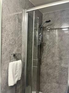 baño con ducha y puerta de cristal en The Lion Hotel, en Llansantffraid-ym-Mechain