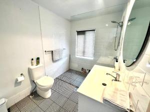 a white bathroom with a toilet and a sink at Sturges Street 22 - Unit 1 in Aitkenvale +7 photos