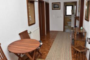 Habitación con mesa de madera, sillas y pasillo. en Apartman Zdenka, en Livno