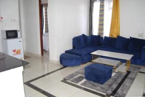 sala de estar con sofá azul y mesa en Annydo Superior Homes en Nairobi