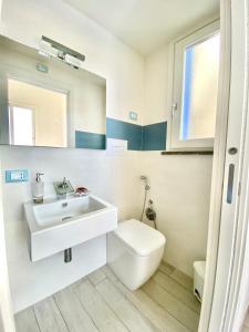 uma casa de banho branca com um lavatório e um WC em Marettimo Appartamenti em Marettimo