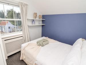 a bedroom with a white bed and a blue wall at Tivoli in Retford