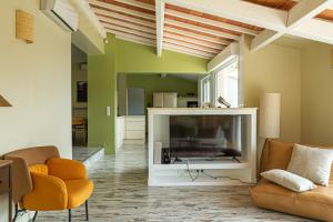 a living room with a large television and orange chairs at La Villa Jausserane in Toulon