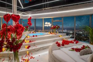 a hotel room with a pool and a bed and flowers at Apartamenty Sky Tower z Wanna Przy Oknie in Wrocław
