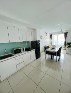 Una cocina con gabinetes blancos y una mesa en ella. en Mansion One l 6pax 2R1B l Seaview l Gleneagle l by PerfectSweetHome, en George Town 15 fotos más