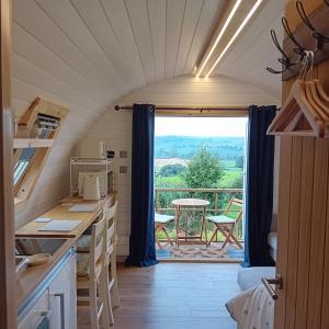 a small kitchen with a view of a balcony at Coombs glamping pods in Danby