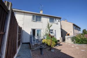 a white house with a gate and a yard at Rawmarsh House, Rotherham for contractors & Families, off-road parking, high speed wifi in Rotherham