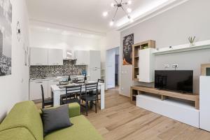 un soggiorno e una cucina con divano e TV di Cobra apartment Gdarco si trova a 600 mt dalla stazione e metropolitana di Sesto Fs a Sesto San Giovanni
